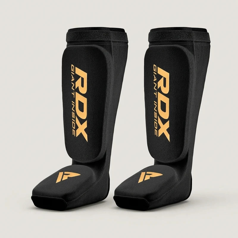 Imagen ilustrativa: Protector tibial RDX para Muay Thai (negro y dorado, talle L/XL)